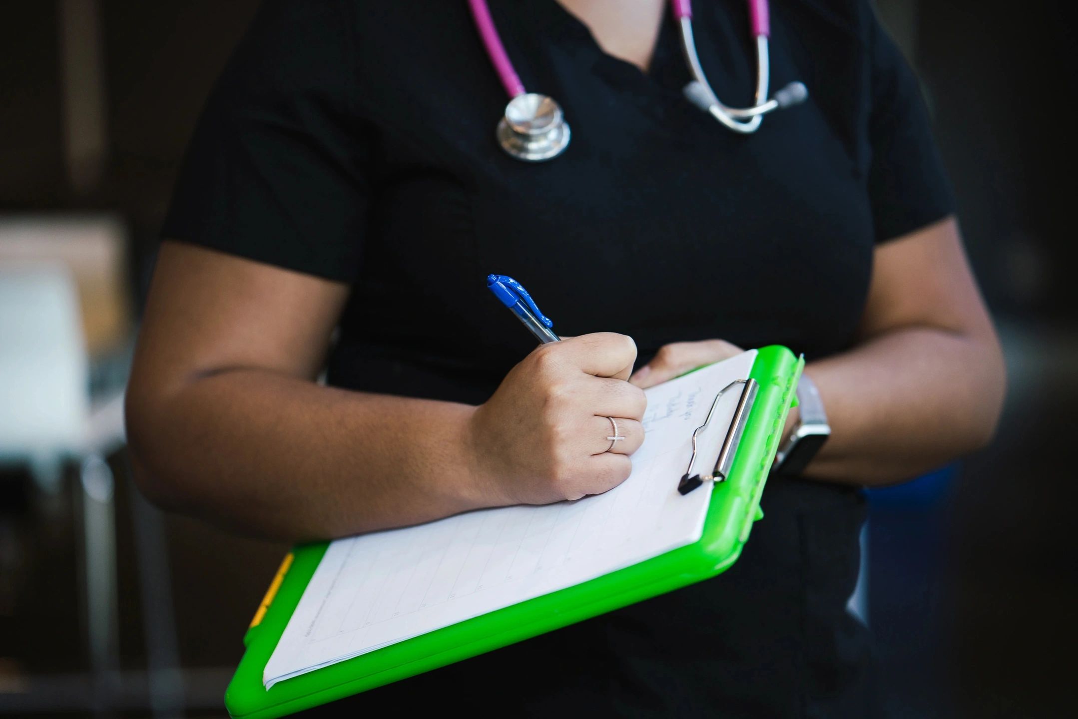 An optometrist is taking notes during an eye care exam